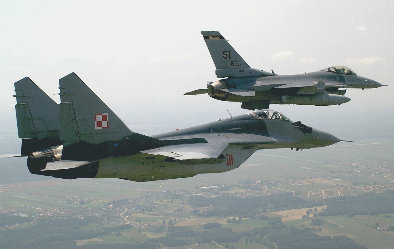 Vep�edu stíha�ka MiG-29 s americkou stíha�kou F-16 vzadu.