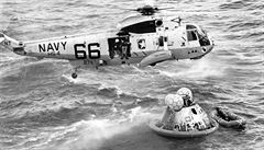Z vrtulník pro astronauty seskoili tyi potápi v ochranných odvech....
