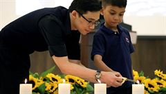 Pozstalí zapalují svíky k uctní památky obtí letu MH17.
