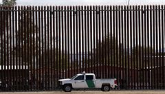 Americký celní a pohraniční vůz vedle hraniční zdi mezi USA a Mexikem.