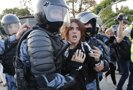 Policisté zatýkají jednu z úastnic protestu.