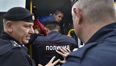 Rutí policisté nakládají protestující do autobus ped zaátkem akce