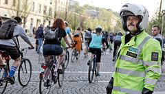 Policista sleduje cyklisty.