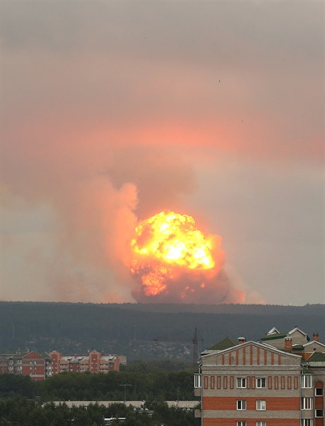 Výhled na stoupající plameny a dým po explozi v muničním skladu poblíž...