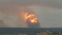 Výhled na stoupající plameny a dým po explozi v muničním skladu poblíž...