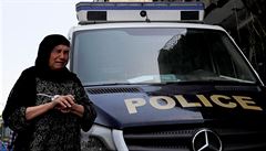Postarí Egypanka pláe zatímco pichází kolem policejního auta k poniené...