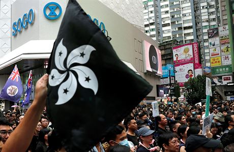 Protestujc drc ern zbarvenou vlajku Hongkongu na znamen odporu.