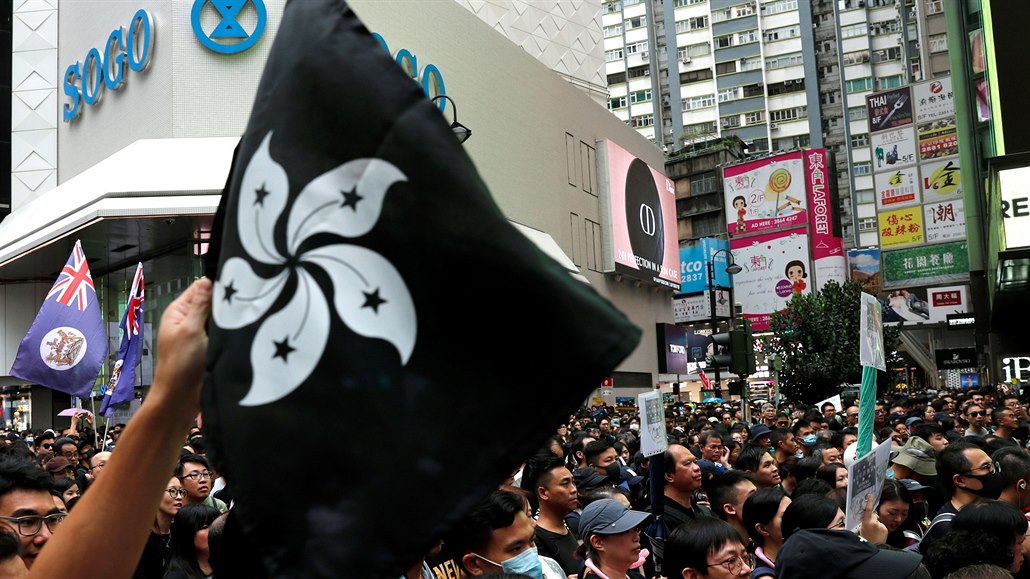 Protestující drící ern zbarvenou vlajku Hongkongu na znamení odporu.