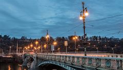 Osvtlený echv most v Praze, který vede pes Vltavu z Námstí Curieových...