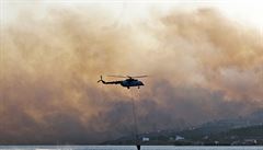 Helikoptéra nabírá moskou vodu, aby pomohla hasit poáry na eckém ostrov...