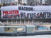 Demonstranti s transparentem proti francouzskému prezidentovi Macronovi