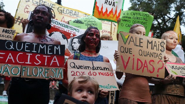 Protestující za lepí klima v brazilském Riu de Janeiru drí cedule s nápisy:...
