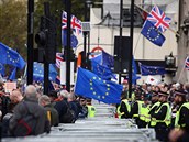 Úastníci mávají vlajkami EU a nesou transparenty vyzývající k zastavení...