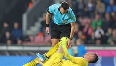 Ji�í Pavlenka se svíjí na zemi, kontroluje ho sudí Ivan Kru�liak