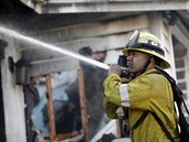 Hasi Calib Willis z losangeleské hasiské stanice prolívá vodou zbytky...
