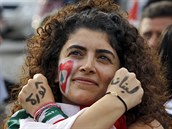 Demonstrující ena má na pekíených rukách v arabtin napsáno: Revoluce...