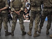 Libanontí vojáci stojí na strái, kdy protivládní protestující sedí na zemi,...