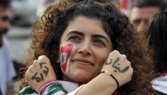 Demonstrující �ena má na p�ek�í�ených rukách v arab�tin� napsáno: �Revoluce�...