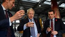 Britský premiér Boris Johnson (uprostřed) v destilérii whisky ve Skotsku.
