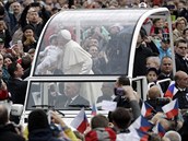 Pape pi cest v papamobilu ehná dítti. V popedí stojí ada eských...