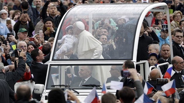 Pape pi cest v papamobilu ehná dítti. V popedí stojí ada eských...