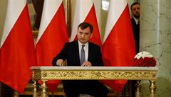 Zbigniew Ziobro podepisuje dokument poté, co byl znovu jmenován ministrem...
