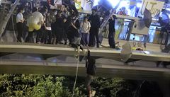 Demonstanti se snaí na lanech dostat z mostu, pod kterým na n ekají...