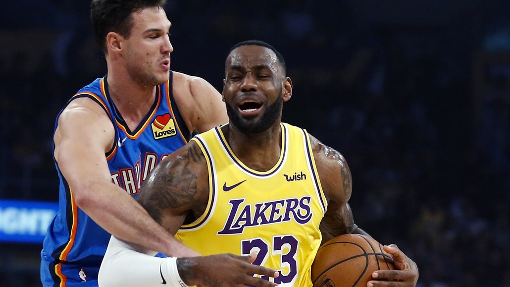 Hráč Los Angeles Lakers LeBron James (vpravo) je faulován protihráčem.