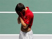 Novak Djokovi schovává hlavu do dlaní po vyazení Srb z Davis Cupu.