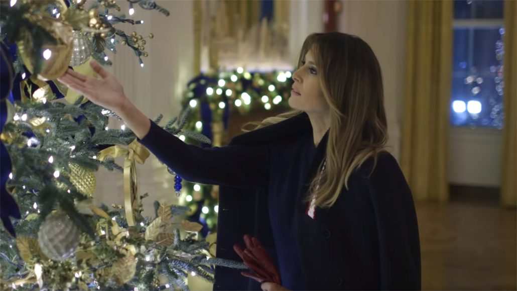 Melanii Trump fascinuje zlatá vánoční koule na stromě.