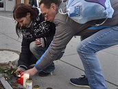Lidé pináejí svíky ped budovu ostravské fakultní nemocnice.