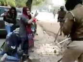 �eny brání demonstranta vlastními t�ly.