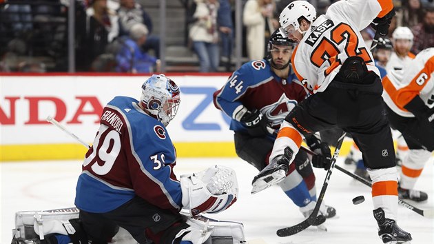 Hrá� Philadelphia Flyers David Ka�e se sna�í posunout puk do brány Pavla...