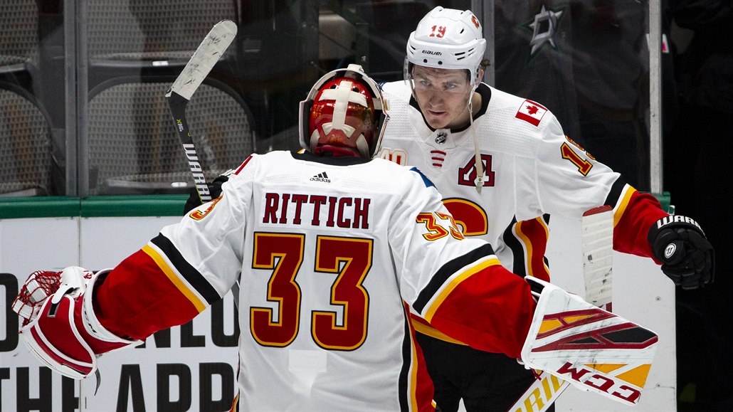 Brankář Calgary Flames David Rittich (33) slaví se spoluhráčem Matthewem...