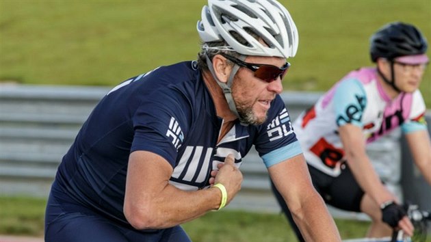 Lance Armstrong pi vyjíce na kole.