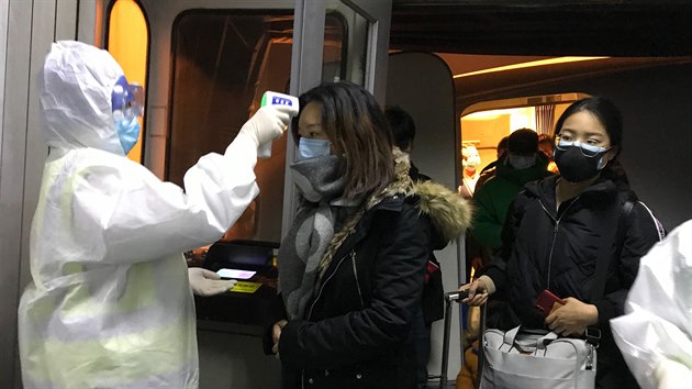 Zdravotníci kontrolují teplotu cestujících v ohnisku nemoci - mst Wu-chan.