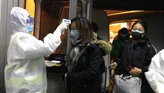Zdravotníci kontrolují teplotu cestujících v ohnisku nemoci - mst Wu-chan.