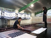 Írántí pracovníci pi výrob vlajek urených zejména k protestním akcím.