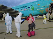 Pracovníci v ochranném obleení kontrolují zavazadla evakuovaných osob z íny...