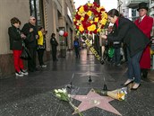 Lidé nosí kvtiny k hvzd Kirka Douglase na chodníku slávy.