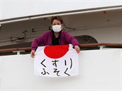 ena drí japonskou vlajku s nápisem nedostek lék.