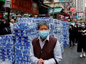 Lidé s maskou procházejí kolem obchodu se zásobou toaletního papíru. Hong Kong