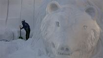 Stavitel dokončuje ledovou sochu medvěda na japonském festivalu sněhových...
