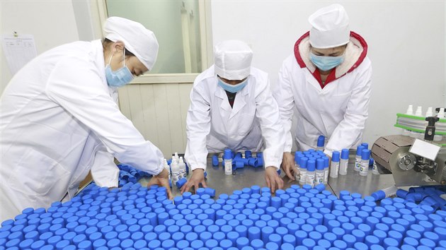Čínští zaměstnanci balí alkoholové dezinfekční prostředky.
