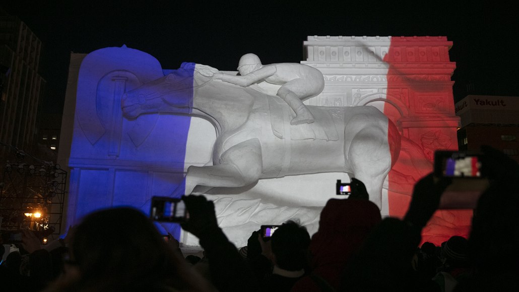 Barvy francouzské vlajky jsou promítnuty na obří ledovou sochu jezdce na koni...