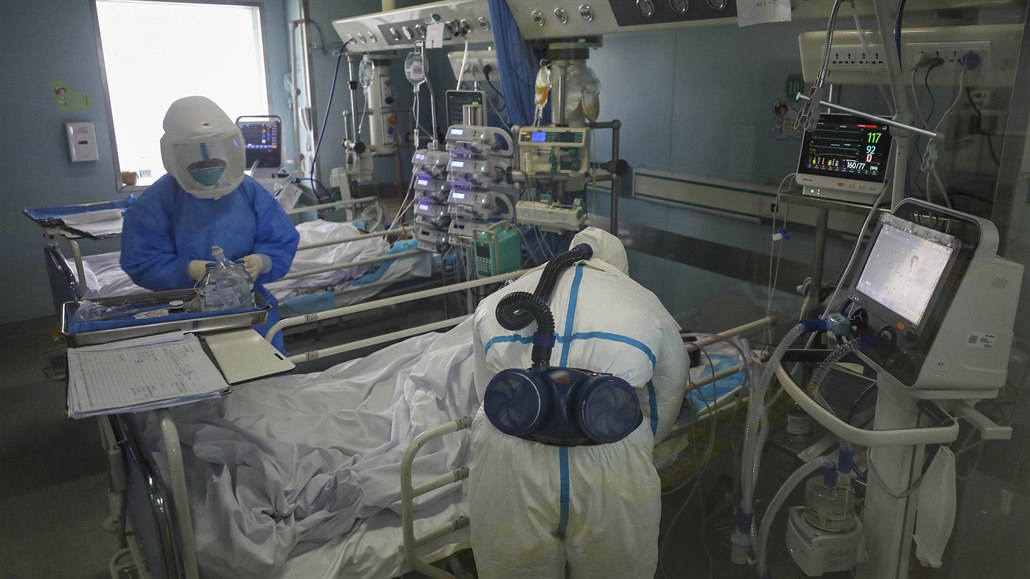 Zdravotníci kontrolují stav pacienta nakaeného koronavirem.
