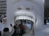 Malý vláek s lidmi projídí pusou ledové sochy znázorující lovka na...