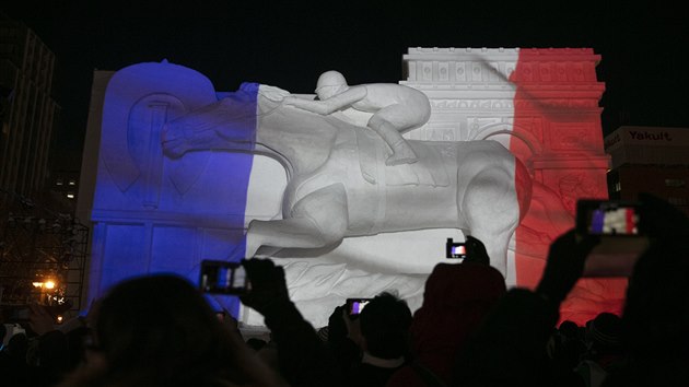Barvy francouzské vlajky jsou promítnuty na obí ledovou sochu jezdce na koni...