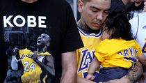 Erik Dominguez drží svou 11měsíční dceru a sleduje stream z rozloučení s Kobe...