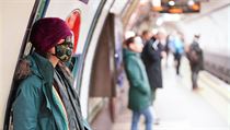 ena s nasazenou ochranou maskou proti koronaviru v londnskm metru.
